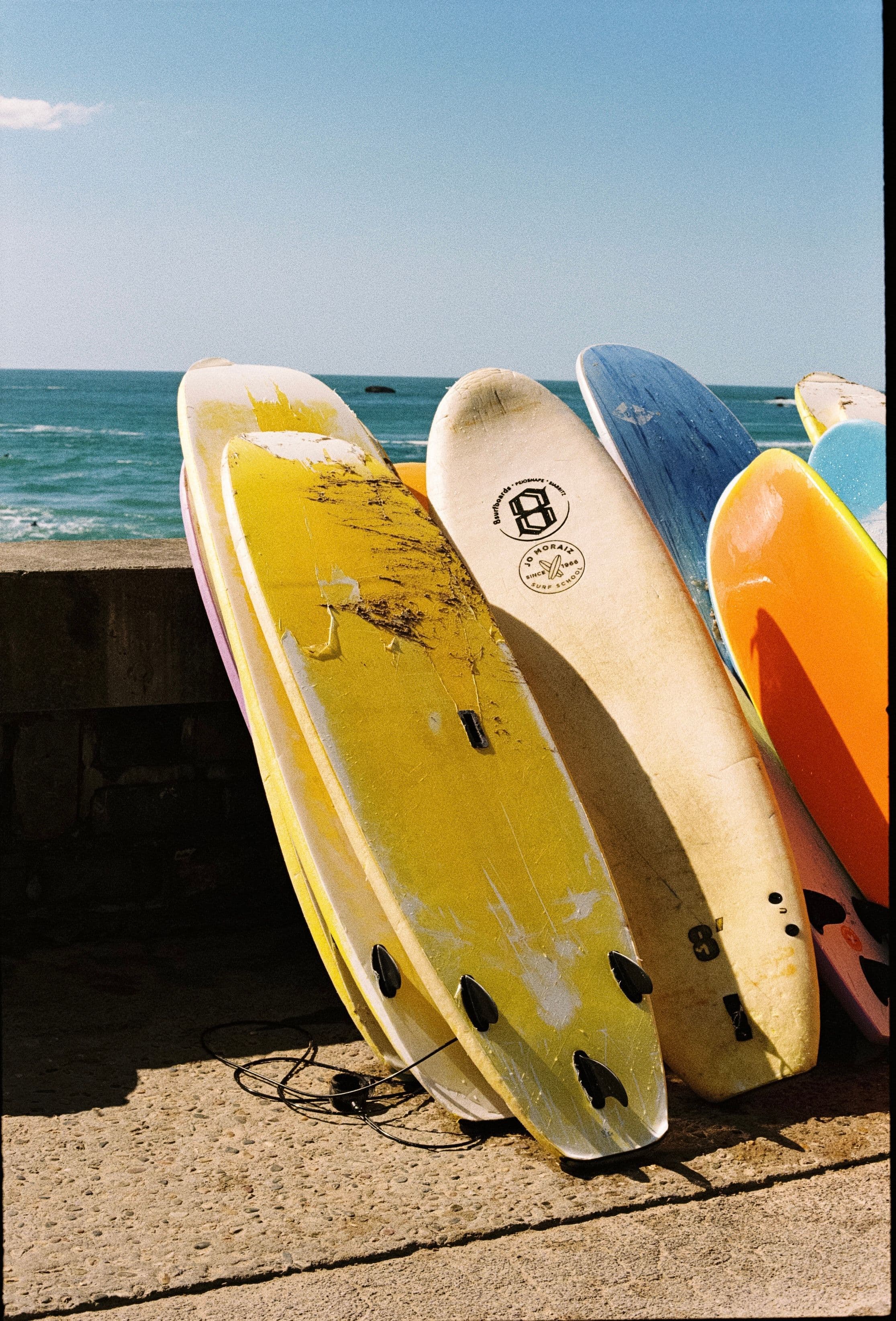 Surfboards leaning against a wall on the beach