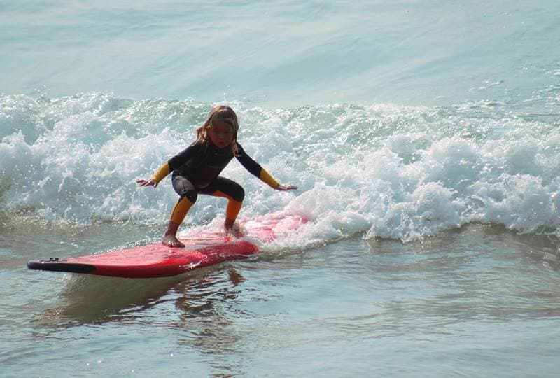 A beginner surfer catching a small wave in the bay
