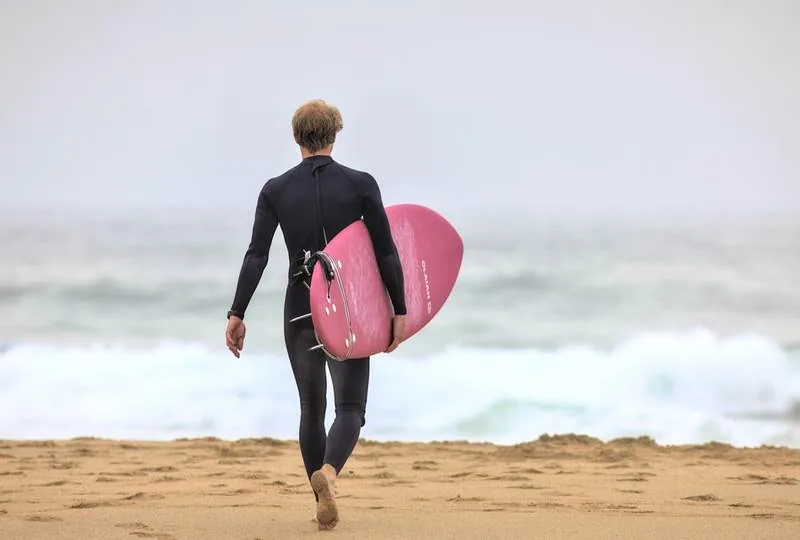 An intermediate surfer turning along the face of a wave